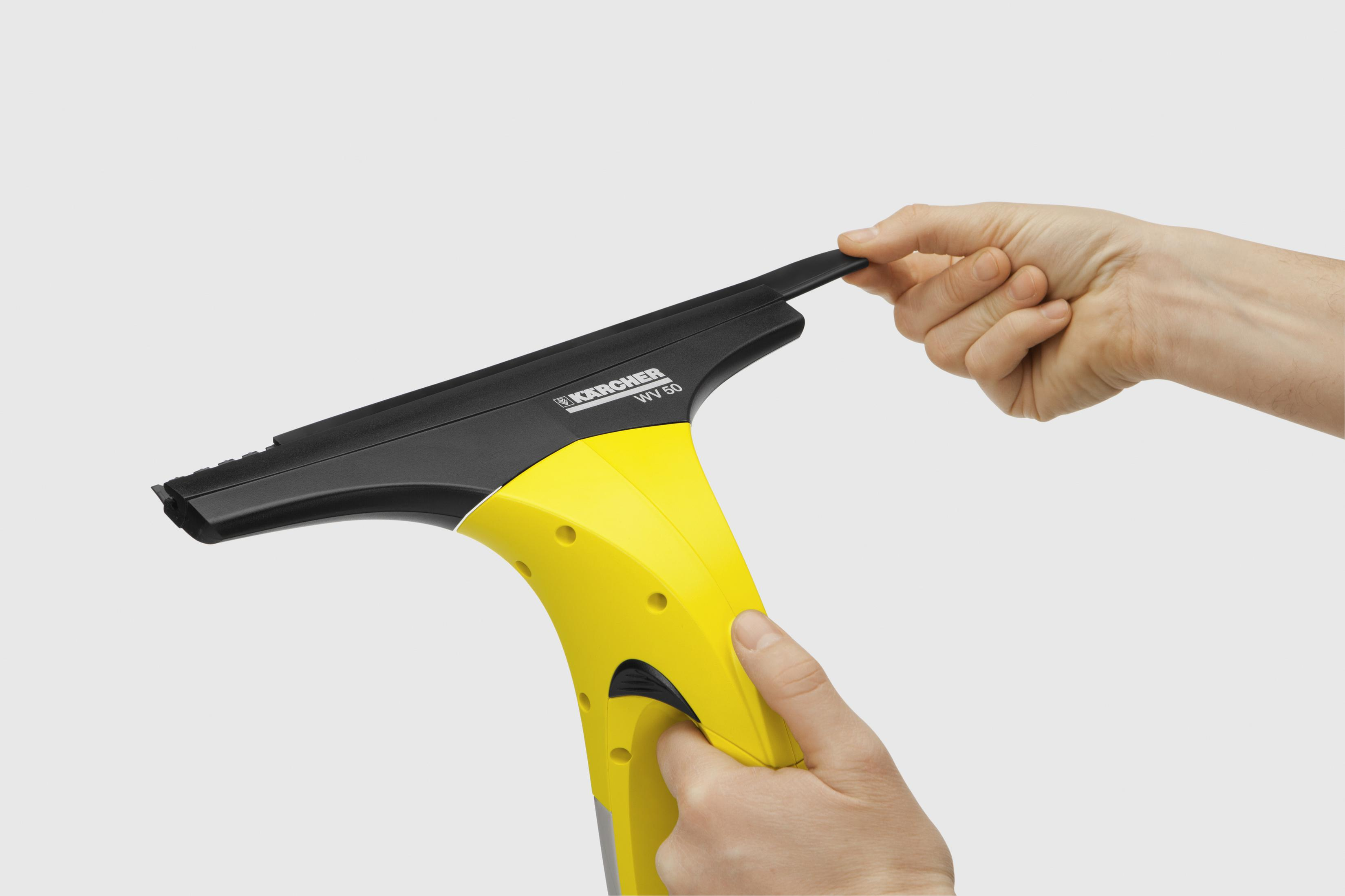 Le mani di una persona tengono un pulitore per vetri giallo e nero.