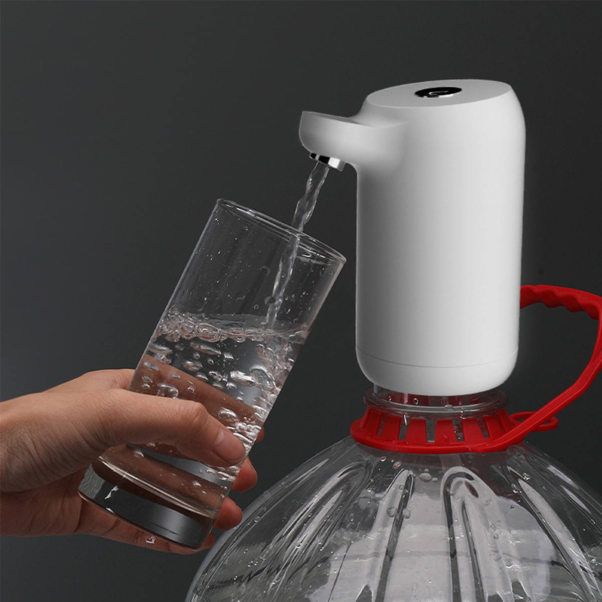 Eine Wasserflaschenpumpe, die Wasser in ein Glas abgibt, auf dunklem Hintergrund.