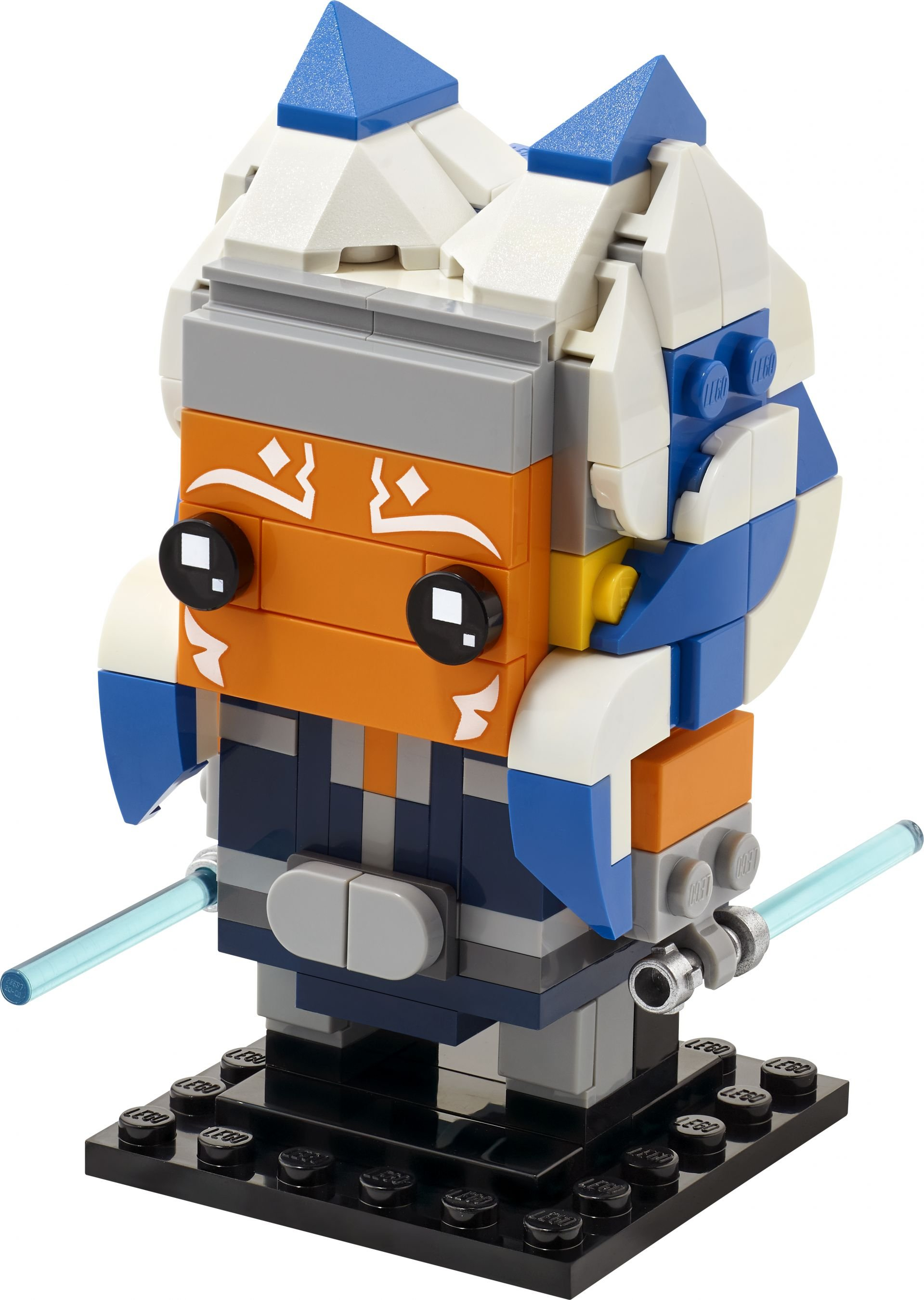 Ein LEGO-Modell von Ahsoka Tano. Es hat ein orangefarbenes Gesicht, weiße Markierungen und blau-weiße Kopfbedeckung, mit zwei Lichtschwertern.