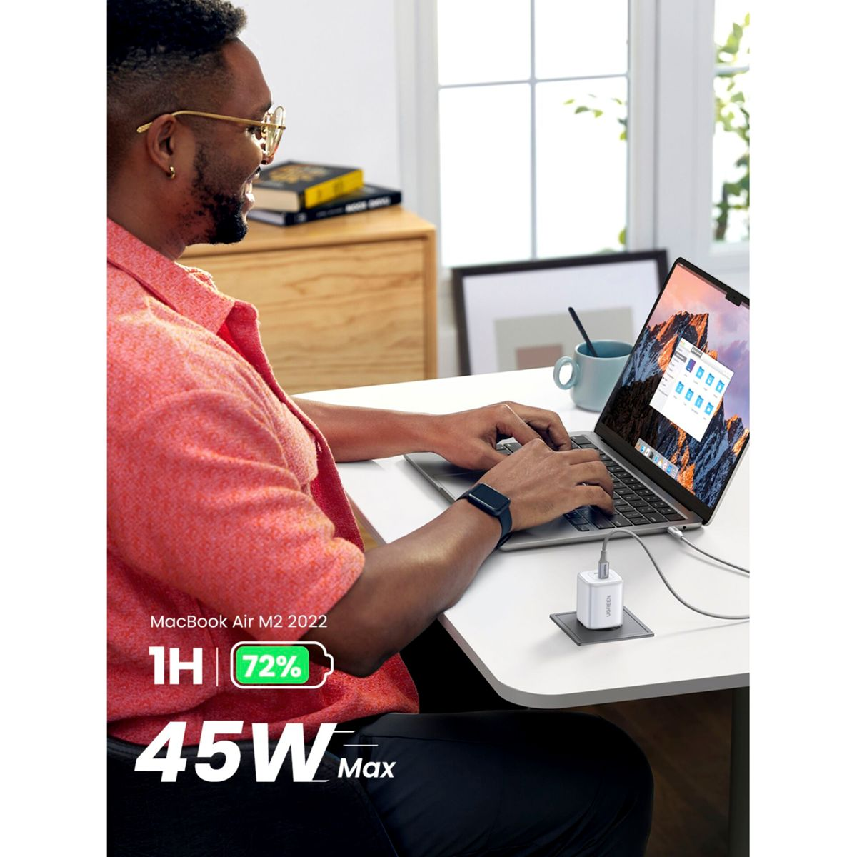 Hombre usando un portátil con cargador. El portátil muestra 72% de batería, 45W de salida máx.