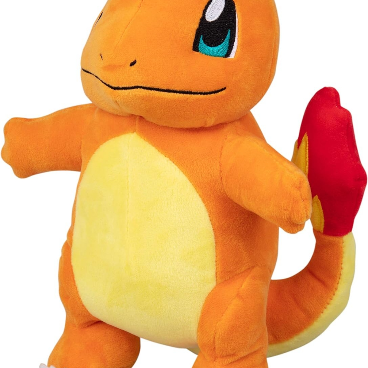 Oranges Charmander-Plüschtier. Gelber Bauch, roter Schwanz. Steht auf weißer Fläche.