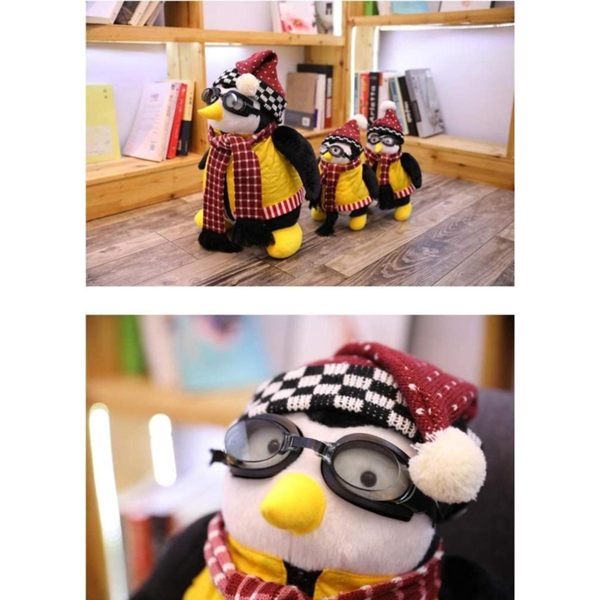 Drei Pinguin-Puppen mit Brille, Hüten und Schals, die in einem Raum auf Holzregalen stehen.
