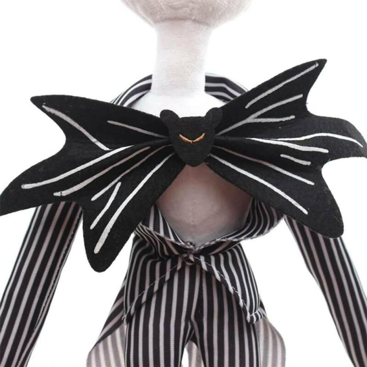 Eine Plüschpuppe von Jack Skellington mit einer fledermausförmigen Fliege. Schwarz-weiß gestreifter Anzug.