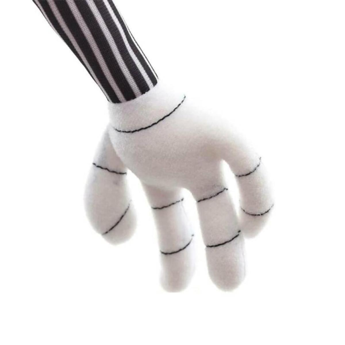 Eine weiße Hand mit schwarz genähten Fingern und einem gestreiften schwarz-weißen Ärmel, der sich von oben erstreckt.