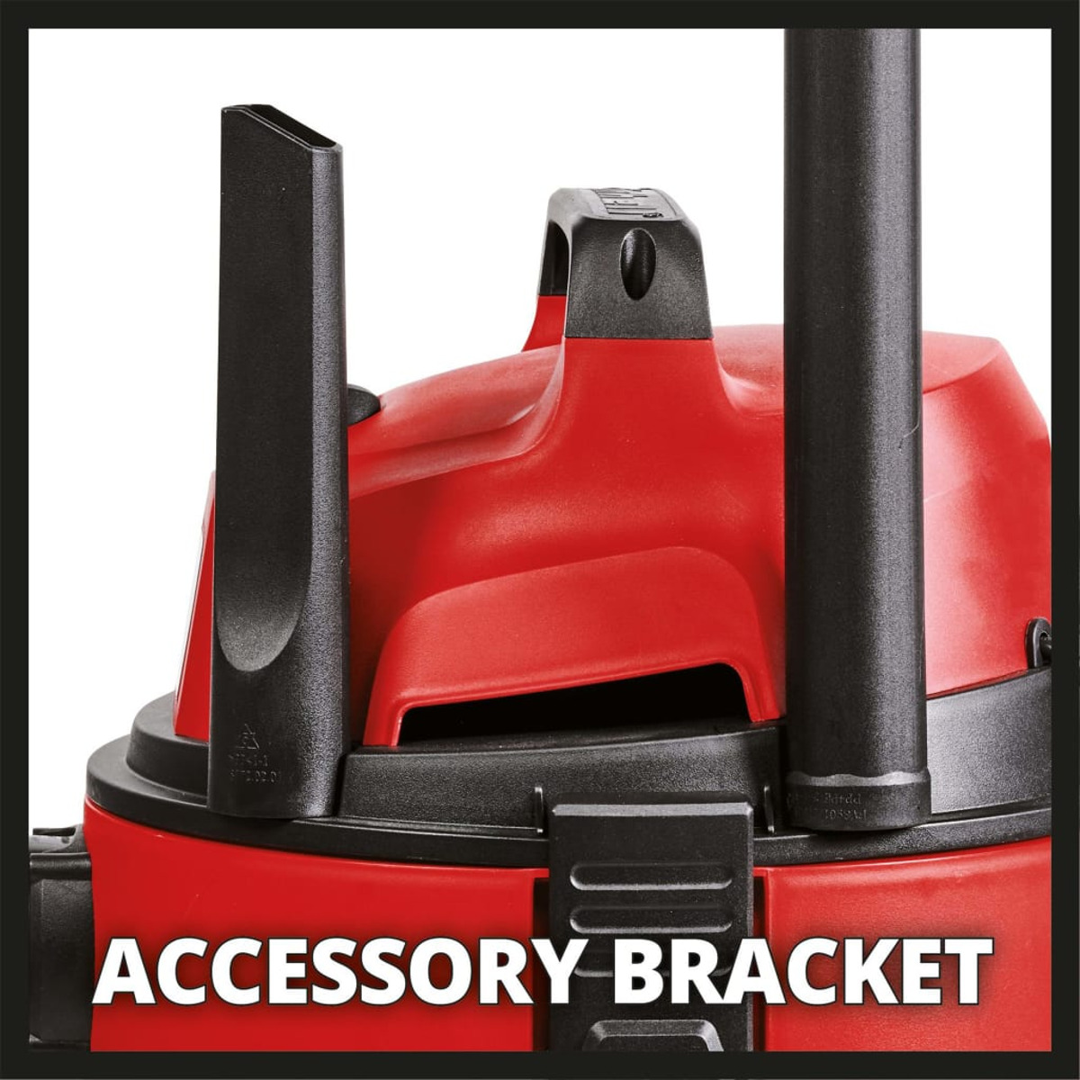 Gros plan du dessus d'un aspirateur rouge. Montre le support d'accessoires.