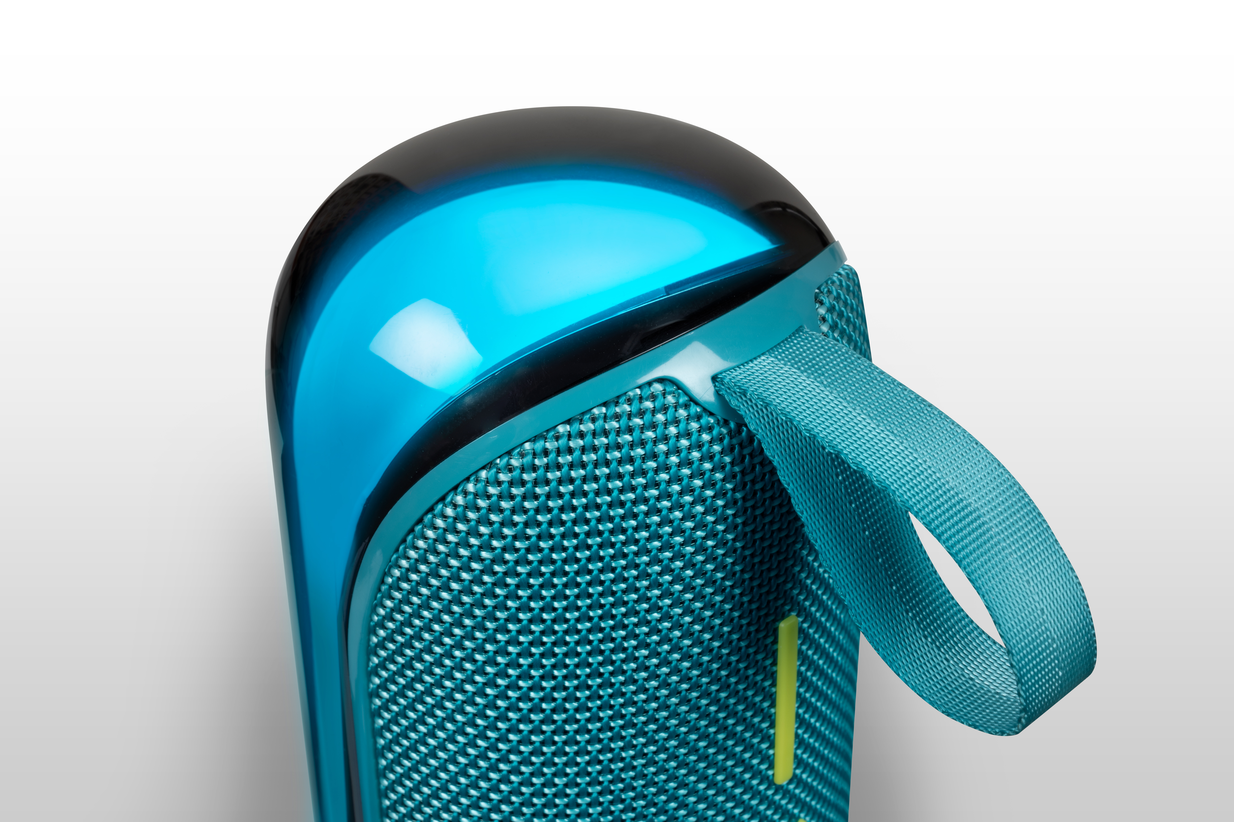 Niebieski i czarny głośnik z turkusowym uchwytem. Głośnik ma siatkową przednią część i błyszczącą górę.