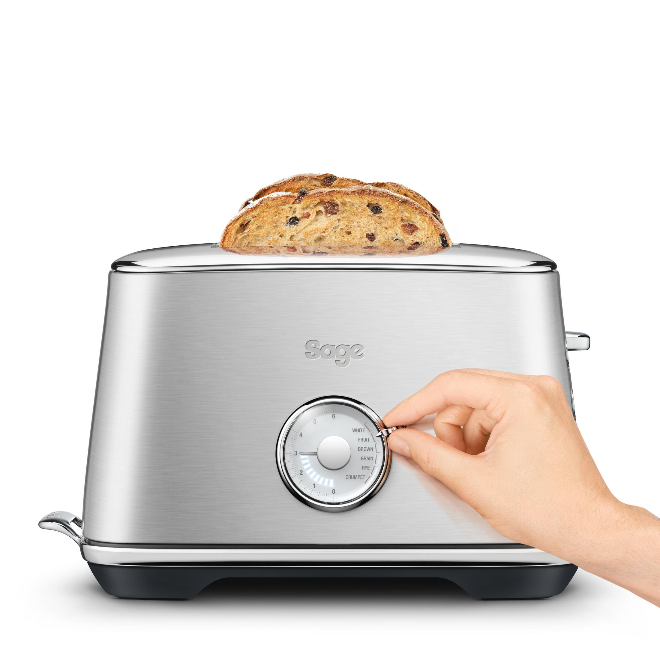 Srebrny toster z kromkami chleba. Ręka obraca pokrętło, aby wybrać stopień opiekania.