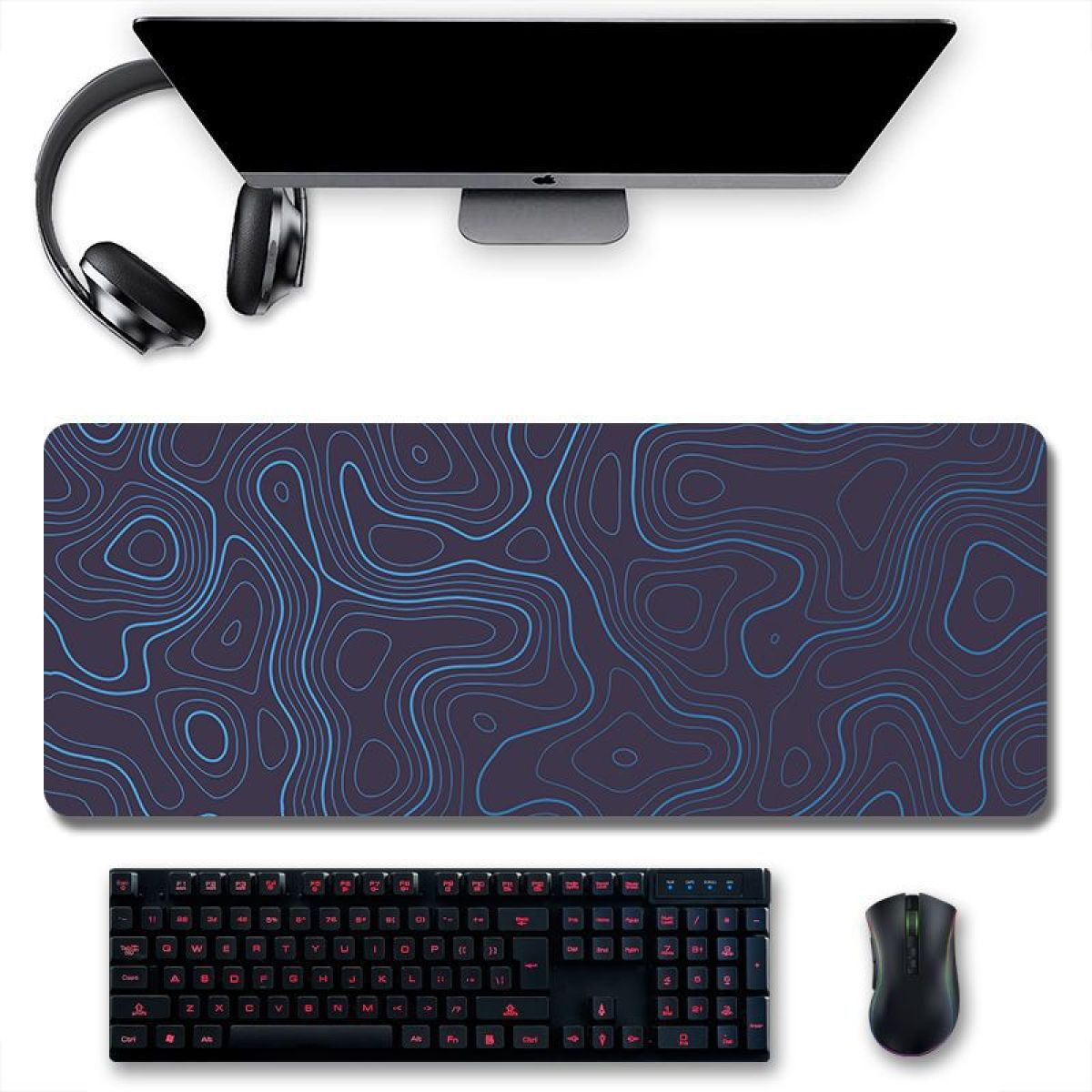 Draufsicht auf den Schreibtisch. Monitor, Kopfhörer, Maus, Tastatur und ein gemustertes Mauspad.