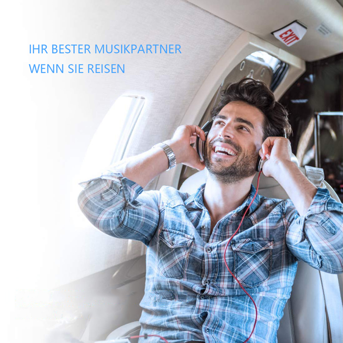 Ein Mann mit Kopfhörern lächelt. Er ist in einem Flugzeug und schaut aus dem Fenster.