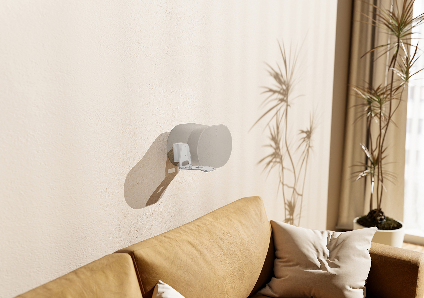 Ein Gerät an einer Wand über einem Sofa montiert. Im Hintergrund befindet sich ein Fenster und eine Pflanze.