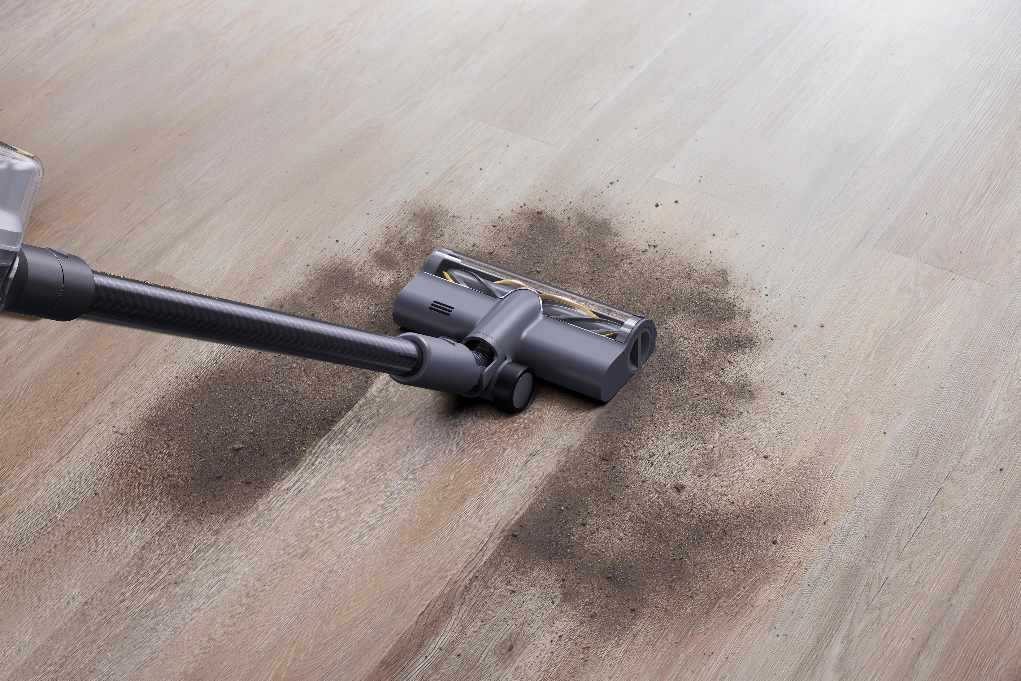 Aspirapolvere che pulisce lo sporco su un pavimento in legno.