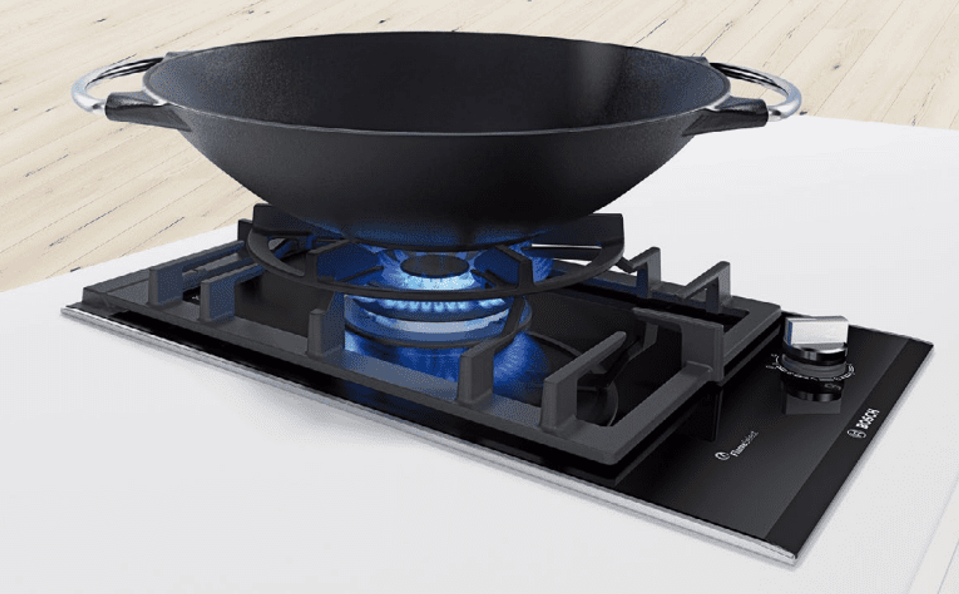 Czarny wok na kuchence gazowej z niebieskim płomieniem.