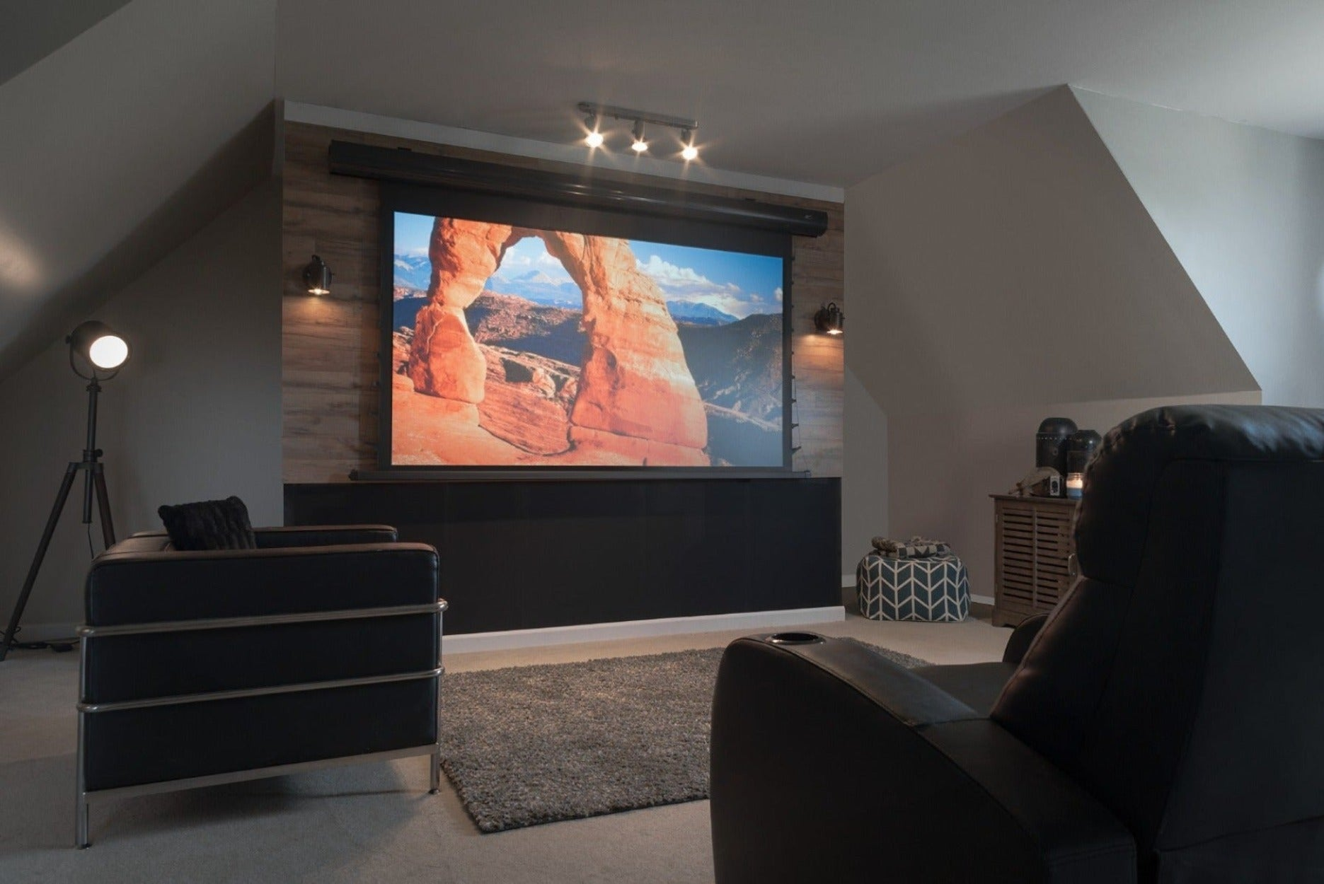 Configuración de cine en casa con una pantalla grande que muestra un arco. Habitación oscura.