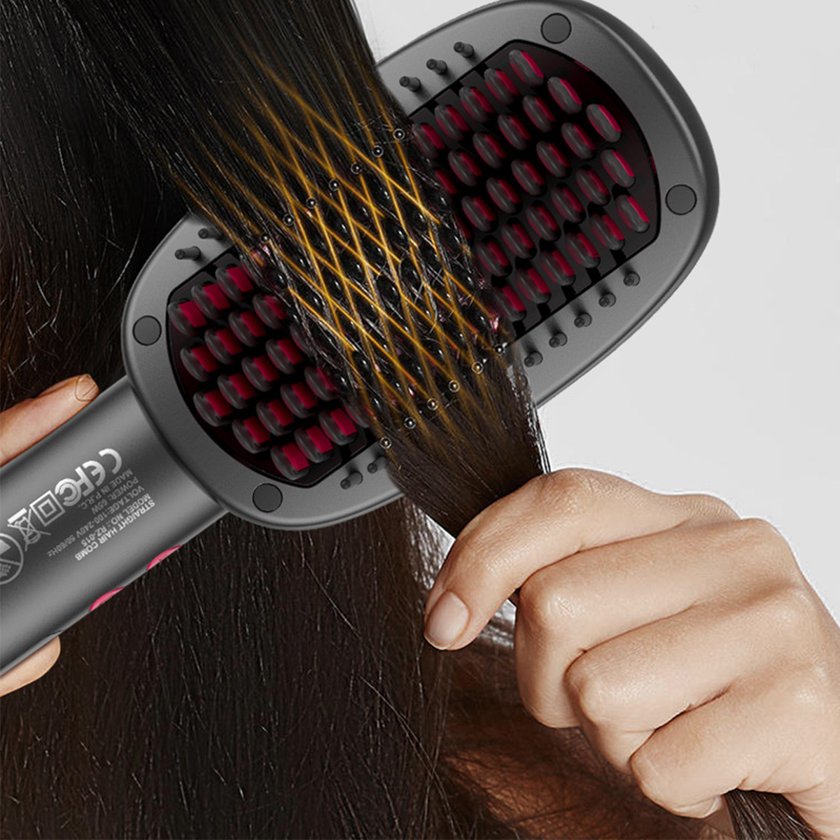 Haarglättungsbürste. Die Bürste ist schwarz. Haare werden geglättet. Weißer Hintergrund.