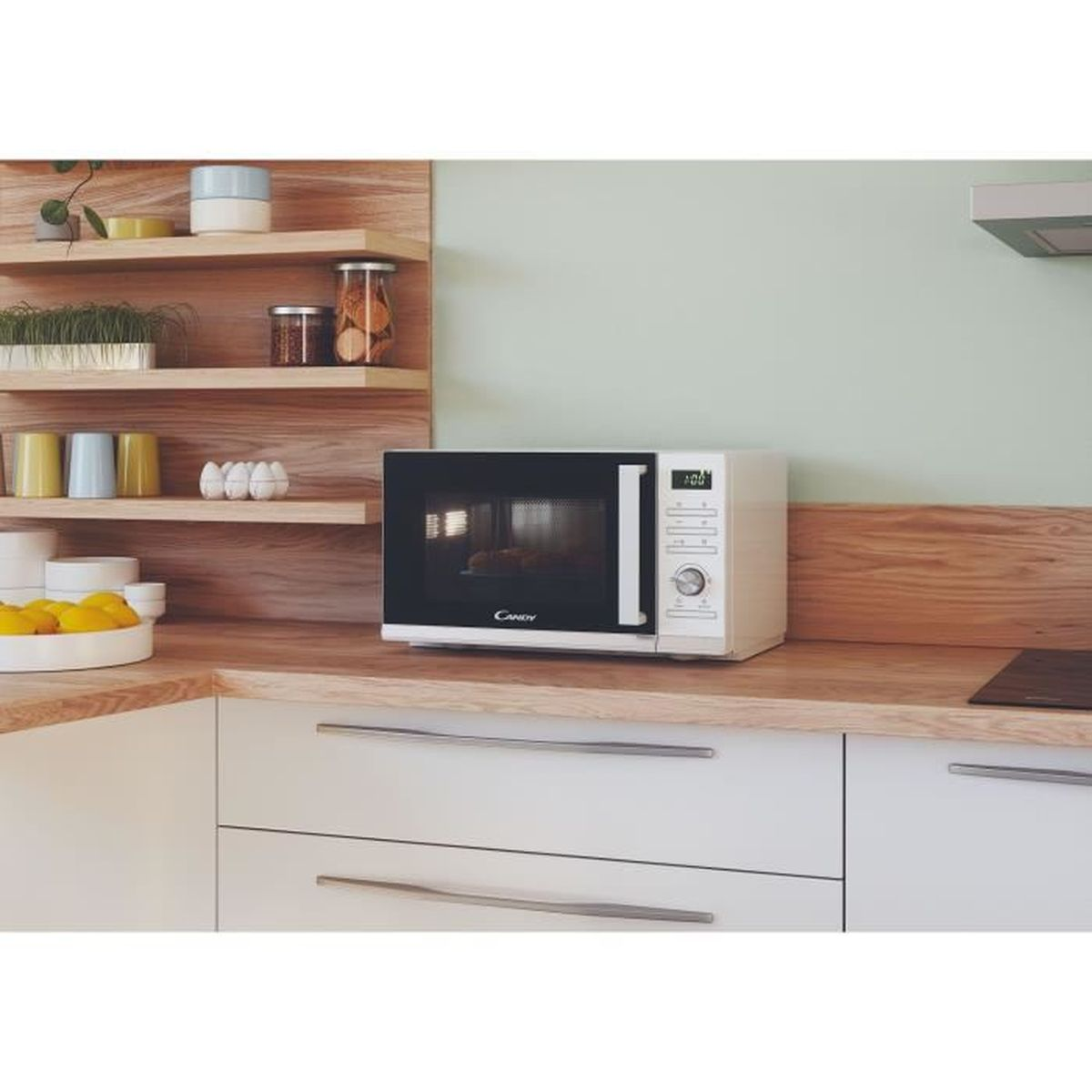 Biała kuchenka mikrofalowa na drewnianym blacie w kuchni.