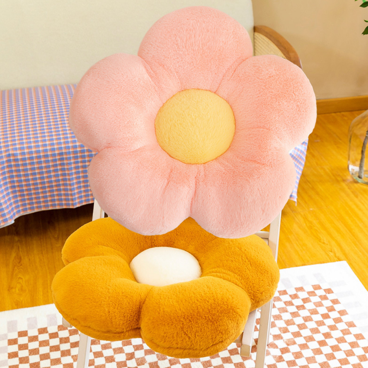 Zwei blumenförmige Kissen. Eines ist rosa und das andere gelb, platziert auf einem Stuhl.