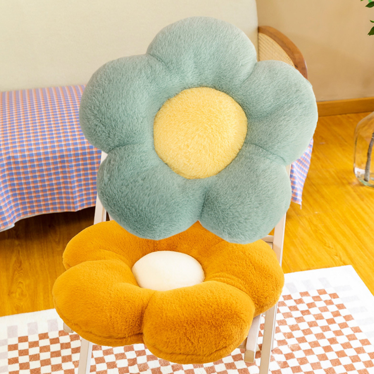 Zwei blumenförmige Kissen. Eines ist grün und gelb, das andere orange und gelb.