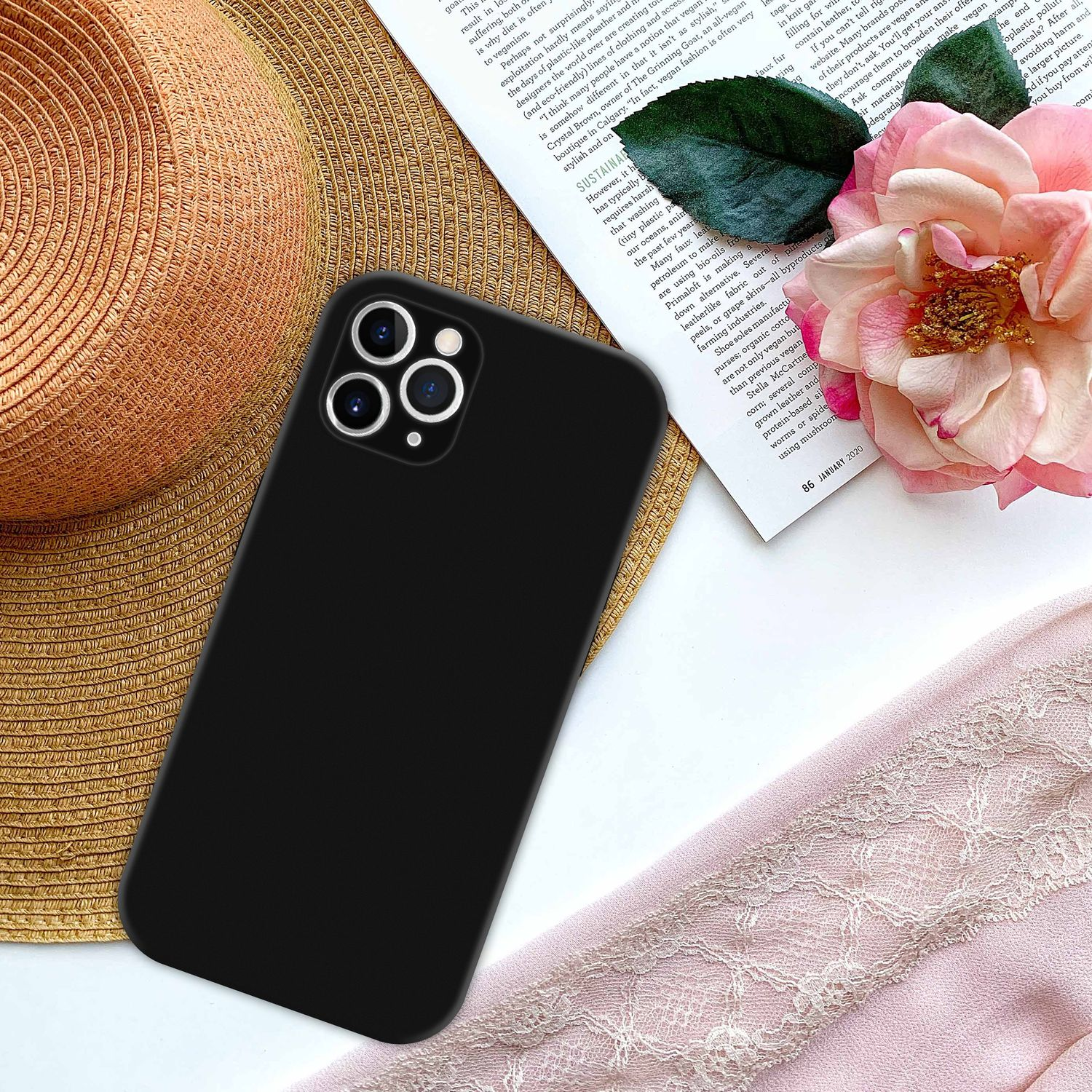 Una custodia nera per telefono con un telefono all'interno, con un cappello, una rosa e una rivista.