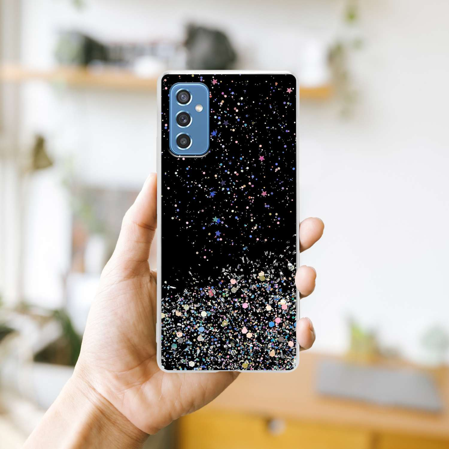 Una custodia per telefono nera con un design glitter nero, tenuta in mano, ha una fotocamera.