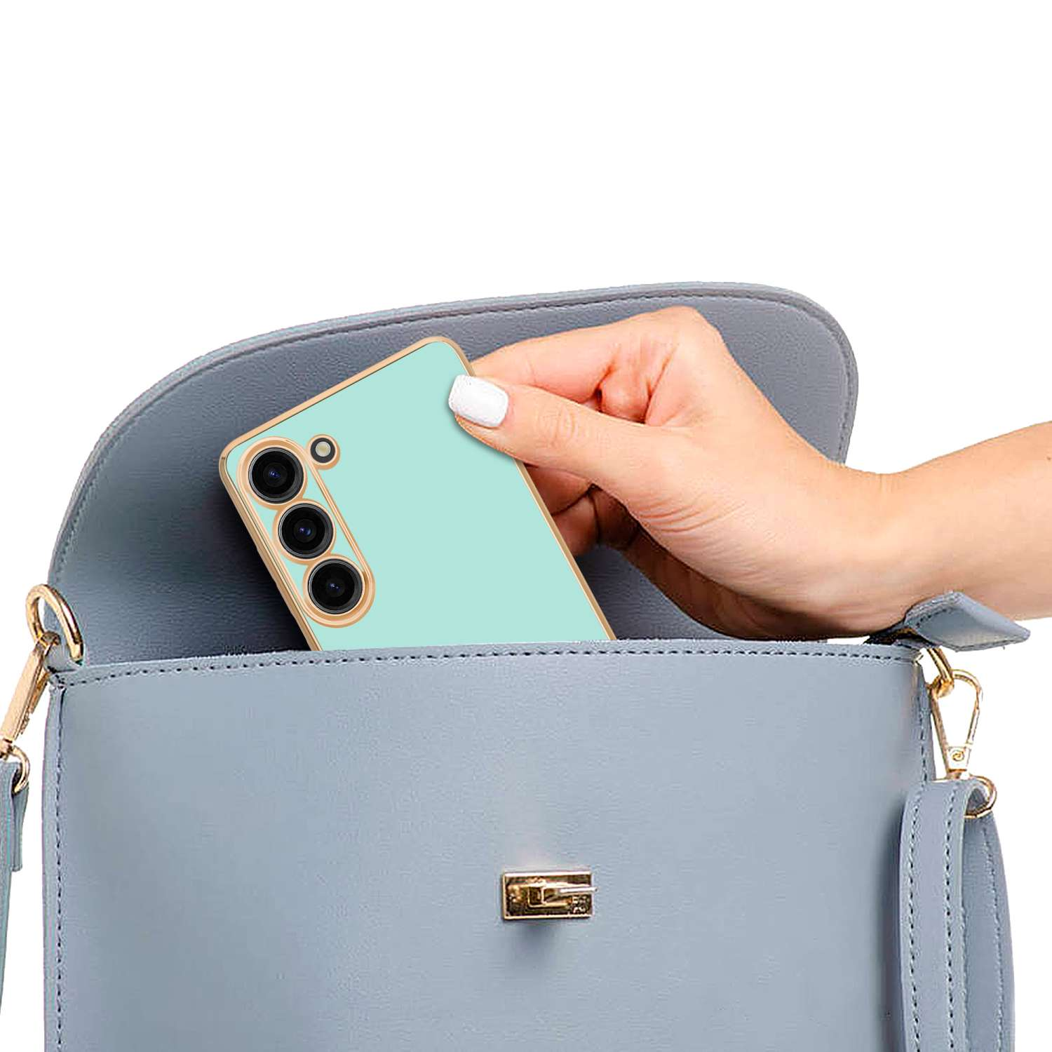 Mano di una persona che mette una custodia per telefono verde in una borsa blu.