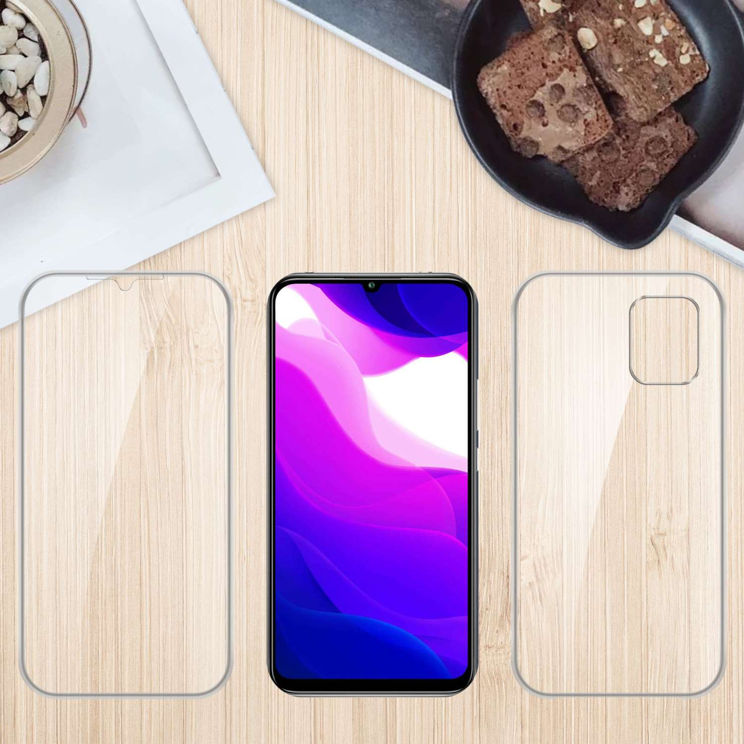 Telefono, protezione schermo e custodia su superficie in legno. Brownies e una pianta sullo sfondo.