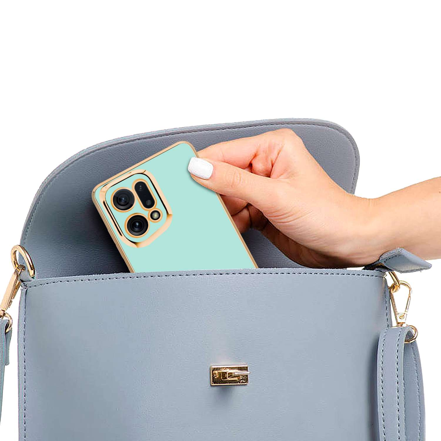 Mano che mette un telefono in una borsa blu. Il telefono ha una custodia dorata.