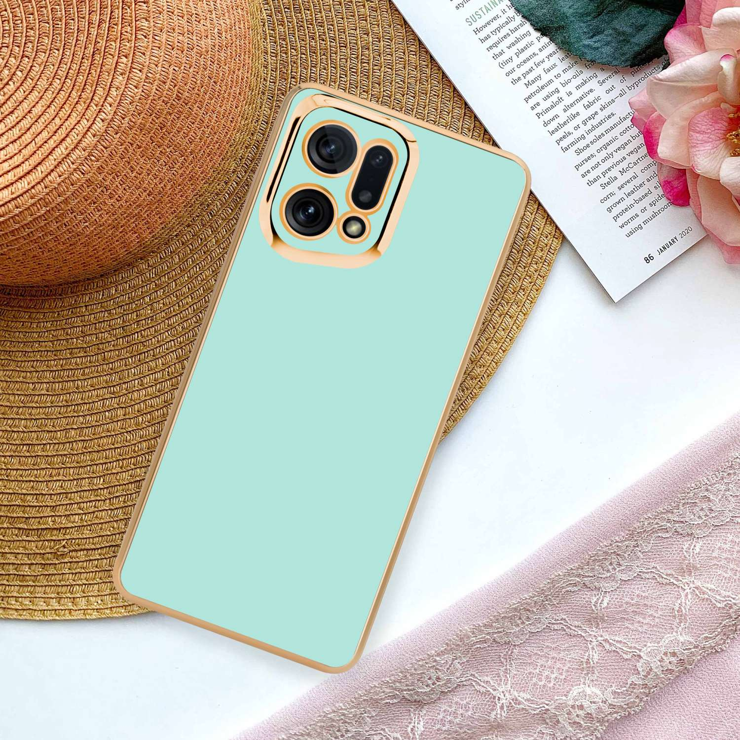 Custodia per telefono verde menta con cornice dorata e area fotocamera, appoggiata su una superficie.
