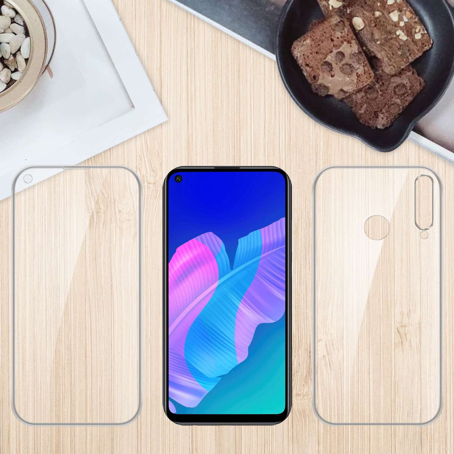 Telefono con custodia trasparente e schermo su un tavolo di legno. Accanto, un vassoio con piccoli dessert.