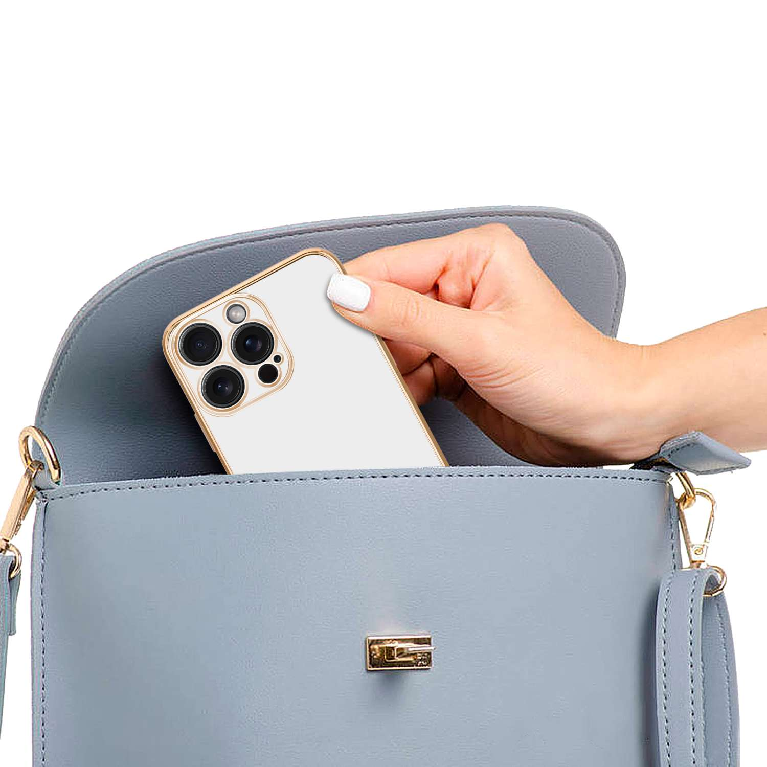 Hand hält weißes Telefon in einer blauen Handtasche.