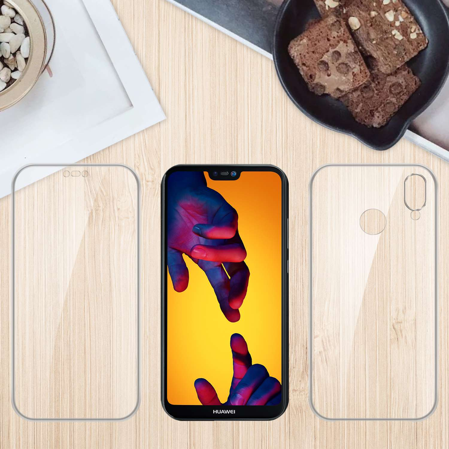 Telefon mit Displayschutzfolie und Hülle auf Holzoberfläche. Brownies und Pflanze befinden sich im Hintergrund.
