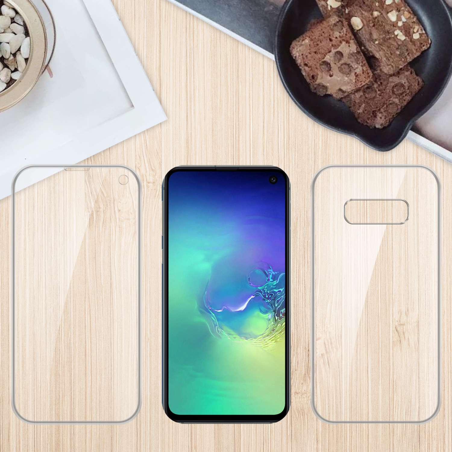 Telefono e due protezioni schermo su superficie in legno. Brownies in un piatto sullo sfondo.