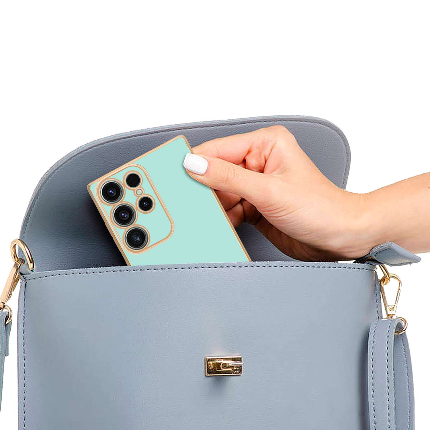 Mano che tiene un telefono turchese con custodia menta, dentro una borsa grigia.