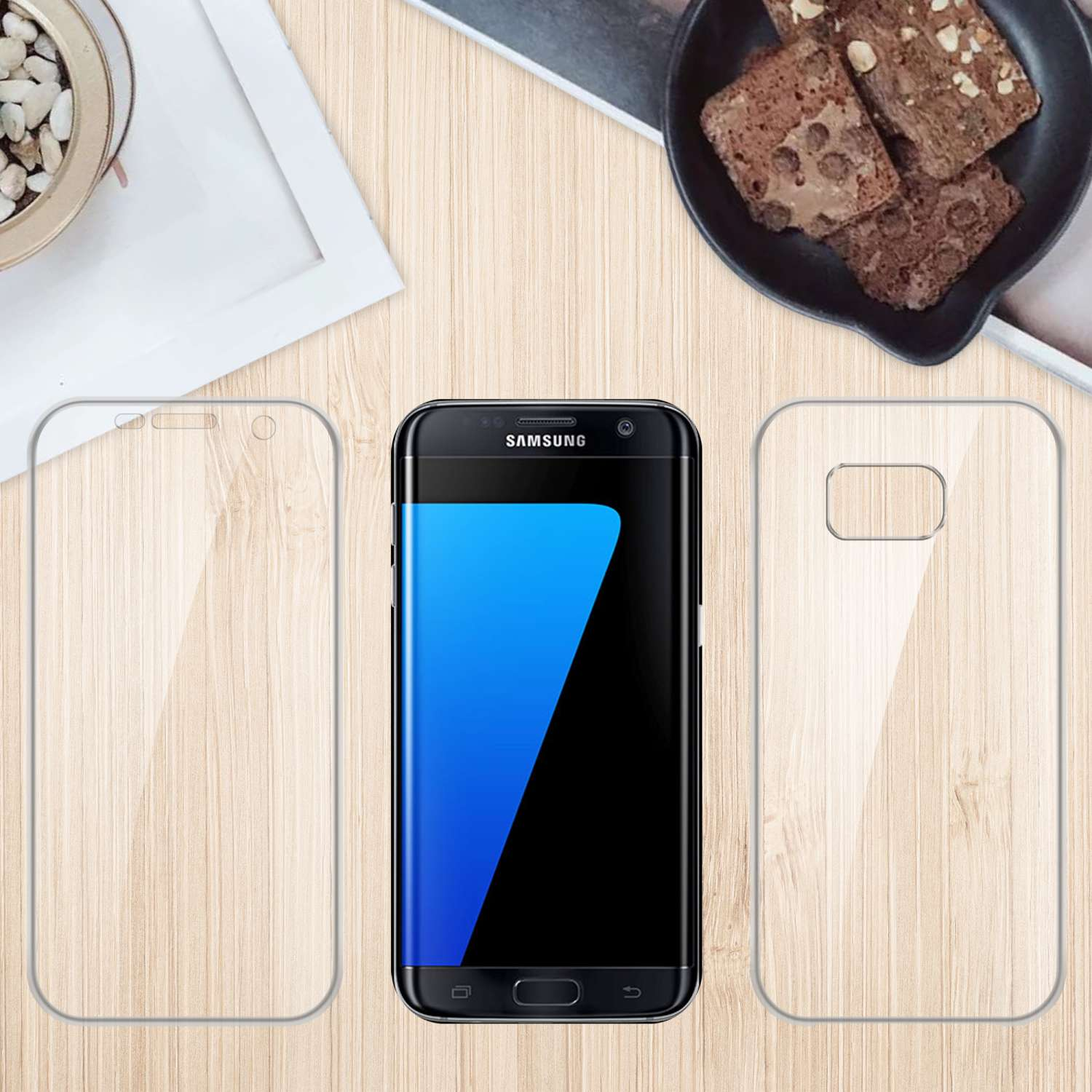 Un telefono, una protezione schermo e una custodia su legno con brownies e una pianta sullo sfondo.