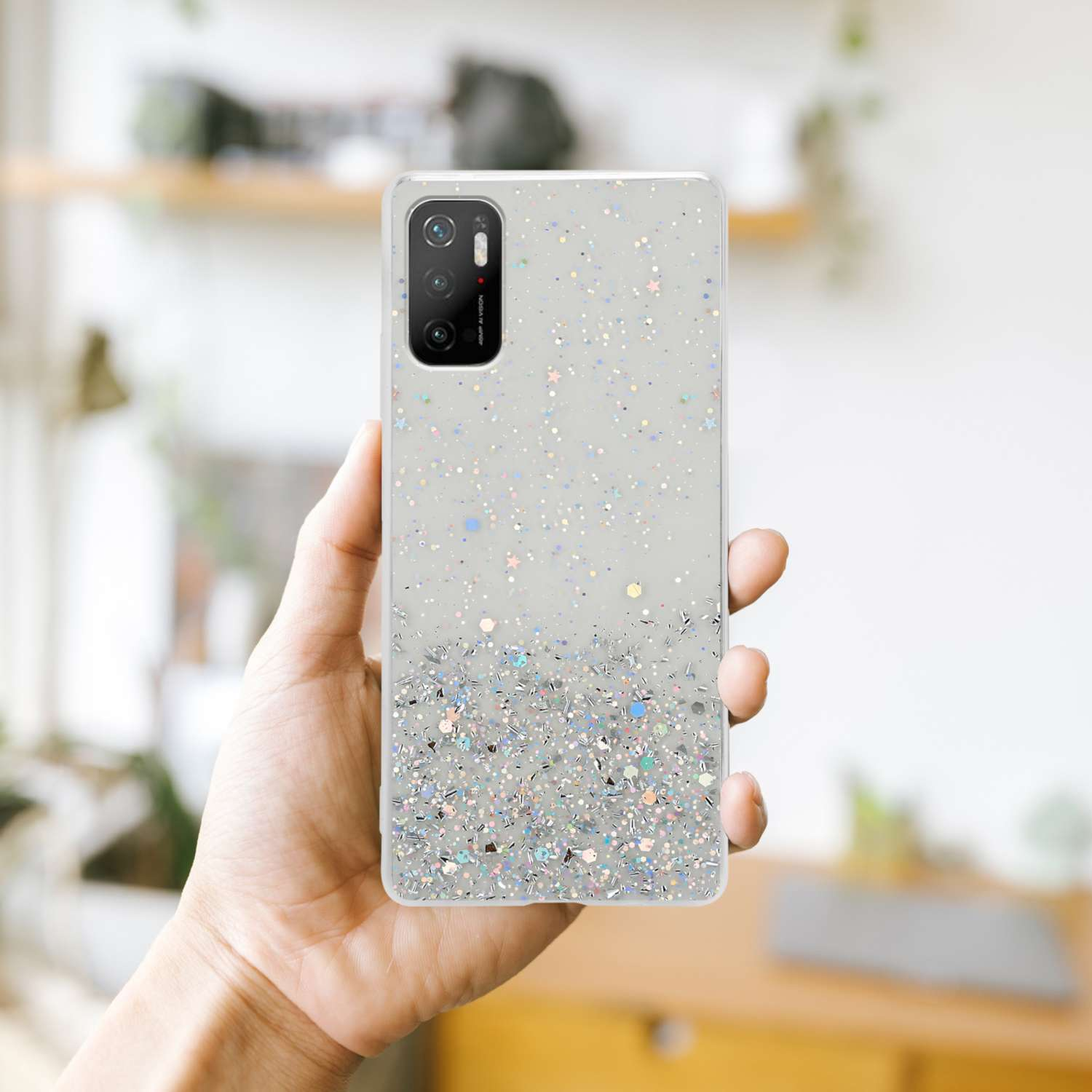 Una mano che tiene un telefono con una custodia glitterata. La custodia ha un design glitterato e una sezione fotocamera.