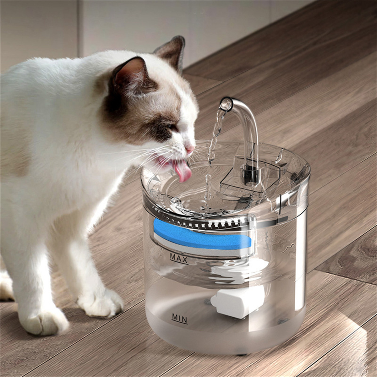 Eine weiß-braune Katze trinkt Wasser aus einem durchsichtigen Haustier-Wasserbrunnen.