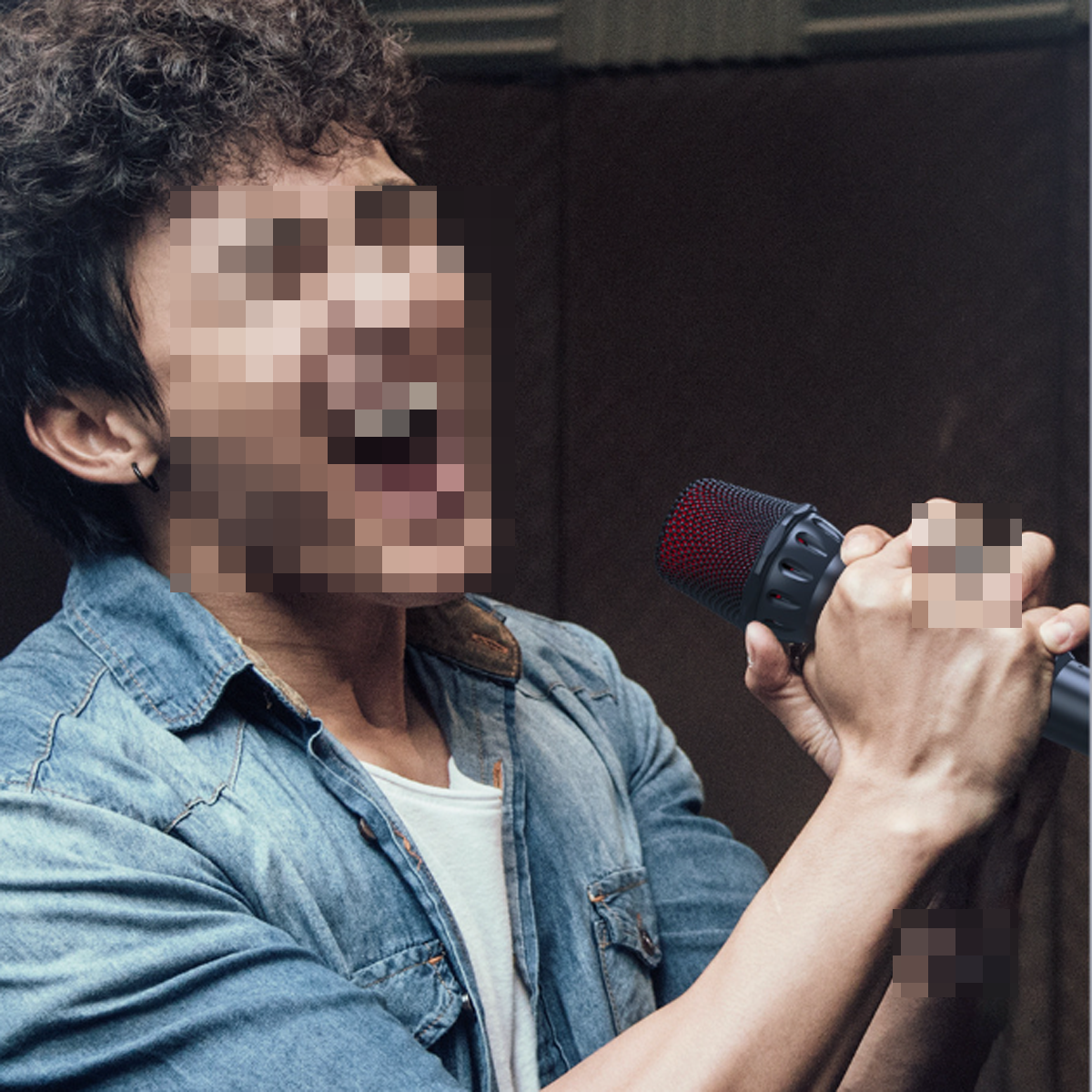 Ein Mann singt in ein Mikrofon. Sein Gesicht ist verpixelt. Er trägt eine Jeansjacke und ein weißes Unterhemd.
