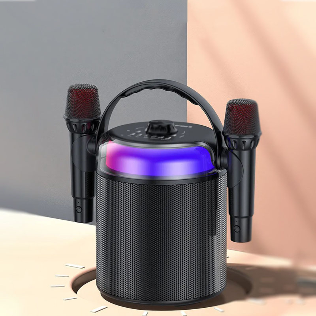Ein schwarzer Karaoke-Lautsprecher mit zwei Mikrofonen. Der Lautsprecher hat bunte Lichter und einen Griff.