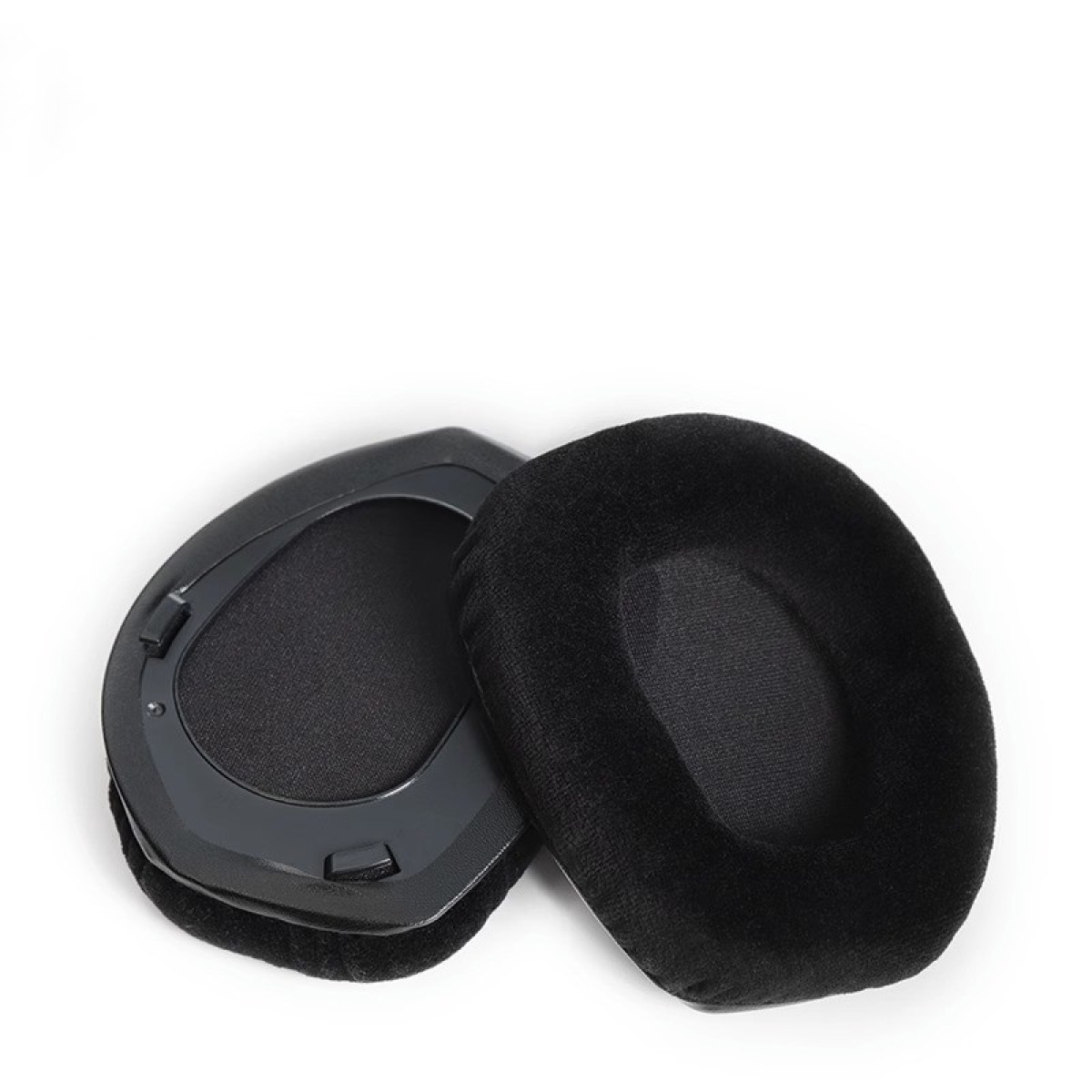 Dwie czarne, owalne nauszniki, prawdopodobnie do słuchawek, na białej powierzchni.