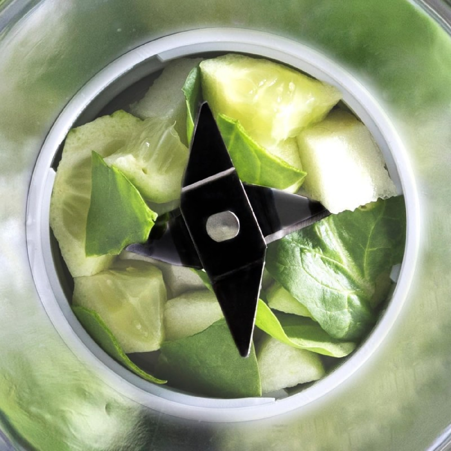 Contenuto del frullatore: frutta e verdura verde tagliata a pezzi in un frullatore.