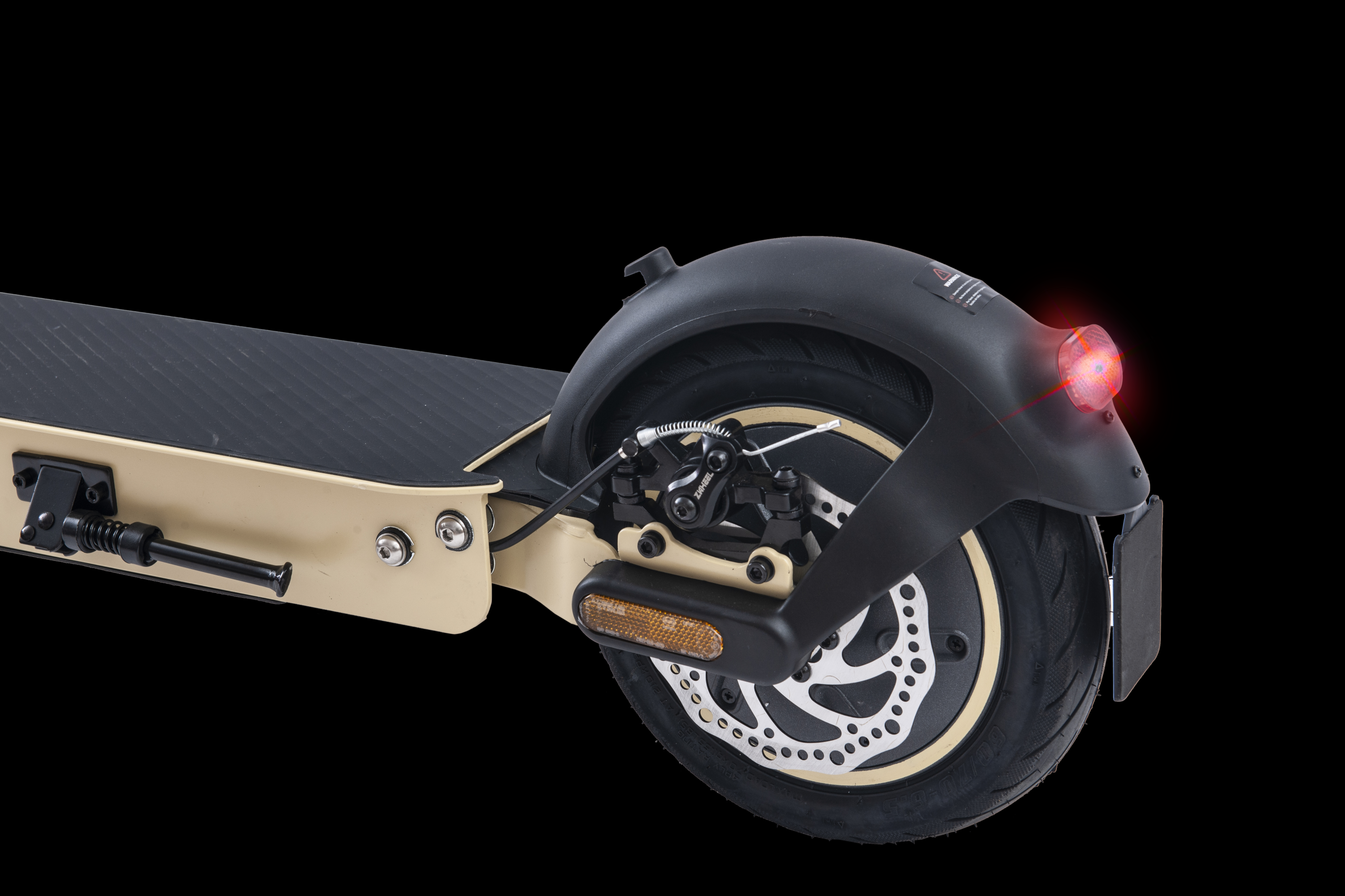 Parte trasera de un scooter. Se ven la rueda, el guardabarros y la luz. El fondo es negro.