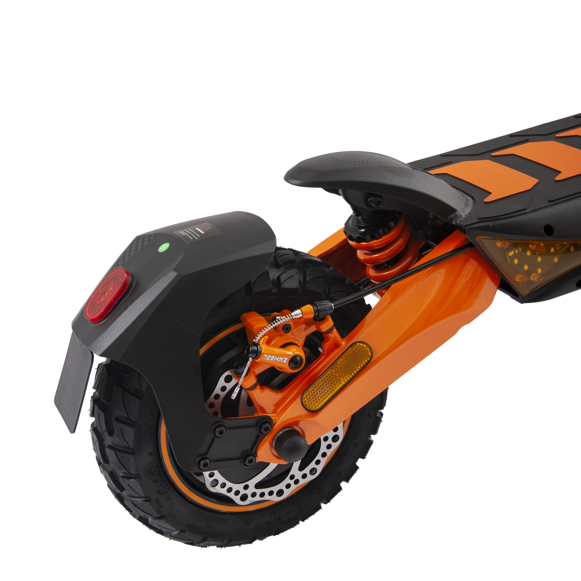 Primer plano de la rueda trasera y el sistema de suspensión de un patinete eléctrico naranja y negro sobre fondo negro.
