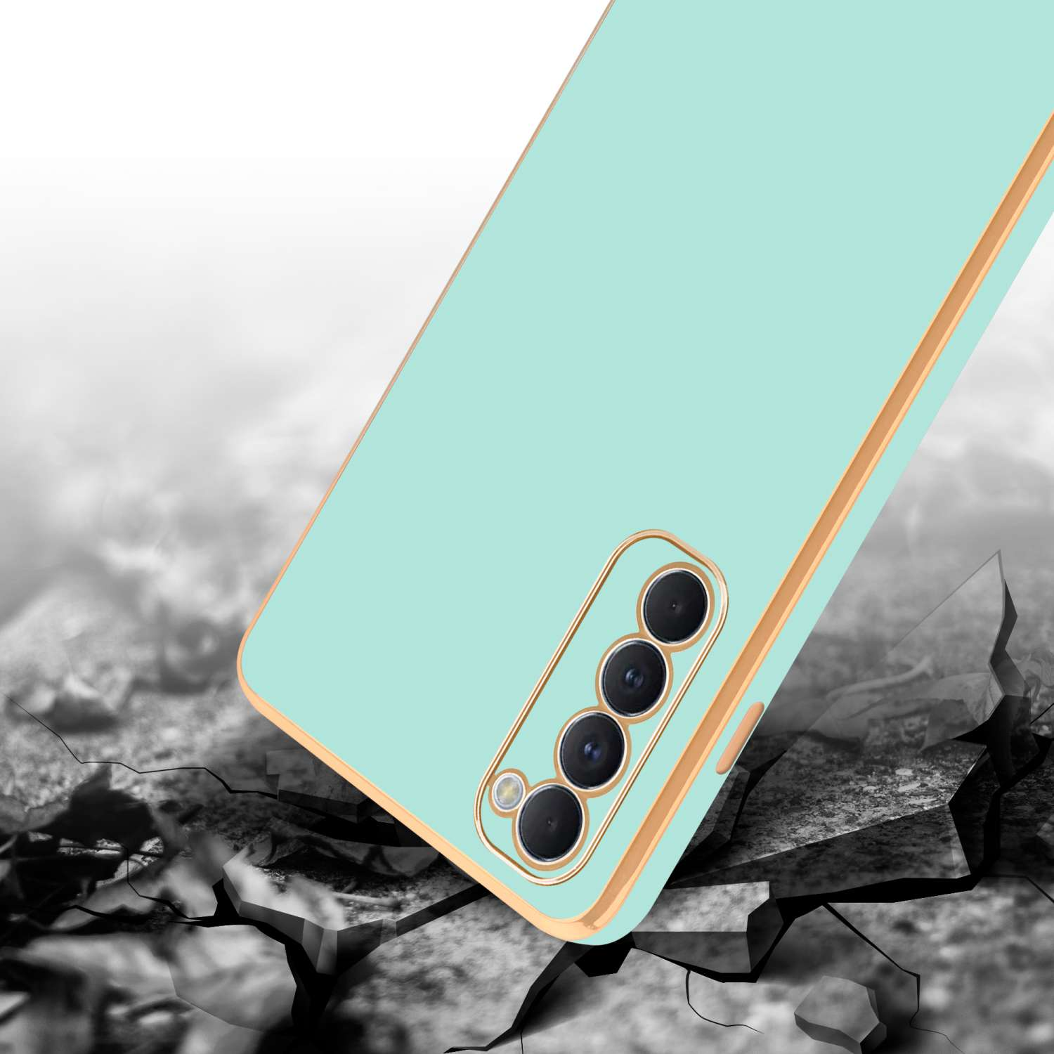 Una custodia per telefono verde menta che cade. Custodia verde chiaro con bordi dorati. Lo sfondo è una superficie incrinata.