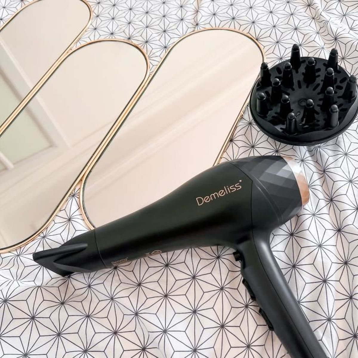 Czarna suszarka do włosów, lustra i dyfuzor. Suszarka jest czarna.