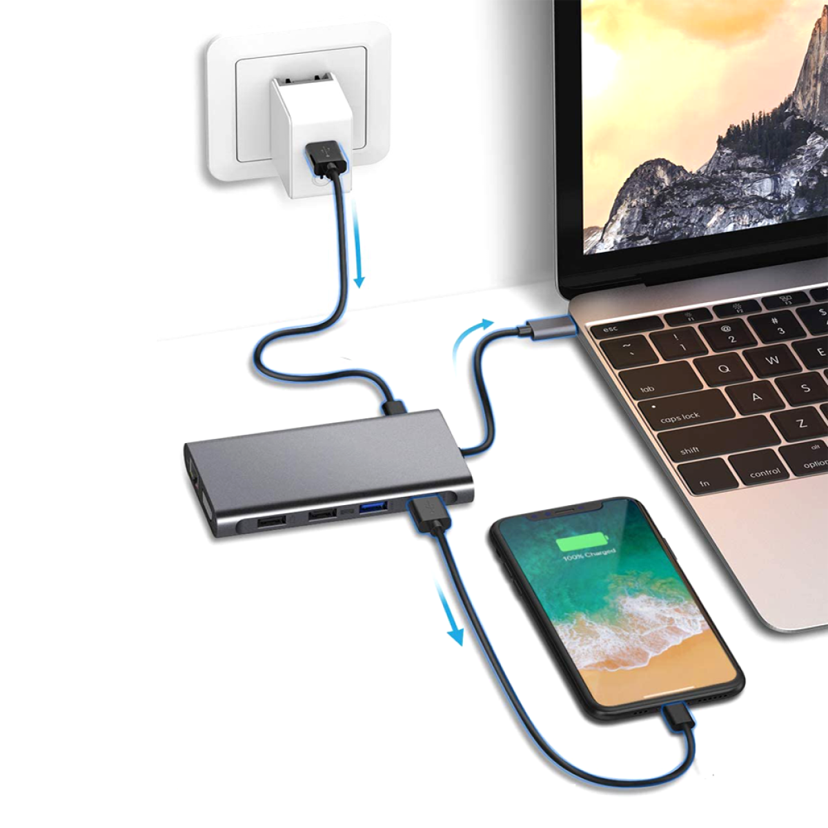 Ein Laptop, das mit einem angeschlossenen Telefon und einem Hub aufgeladen wird, alles an einer Steckdose.