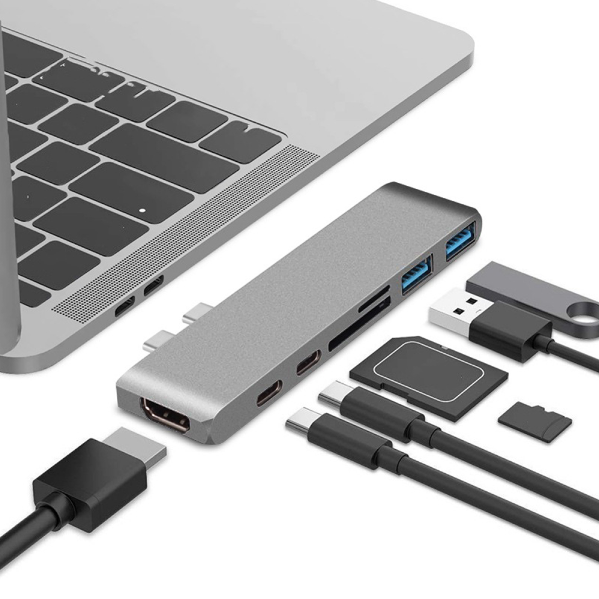 Ein silberner Hub mit mehreren Anschlüssen, der mit einem Laptop verbunden ist, verschiedene Zubehörteile.