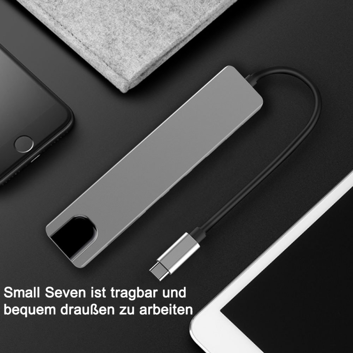 Ein silberner USB-C-Hub mit schwarzem Kabel, verbunden mit einem Telefon und einem Tablet.