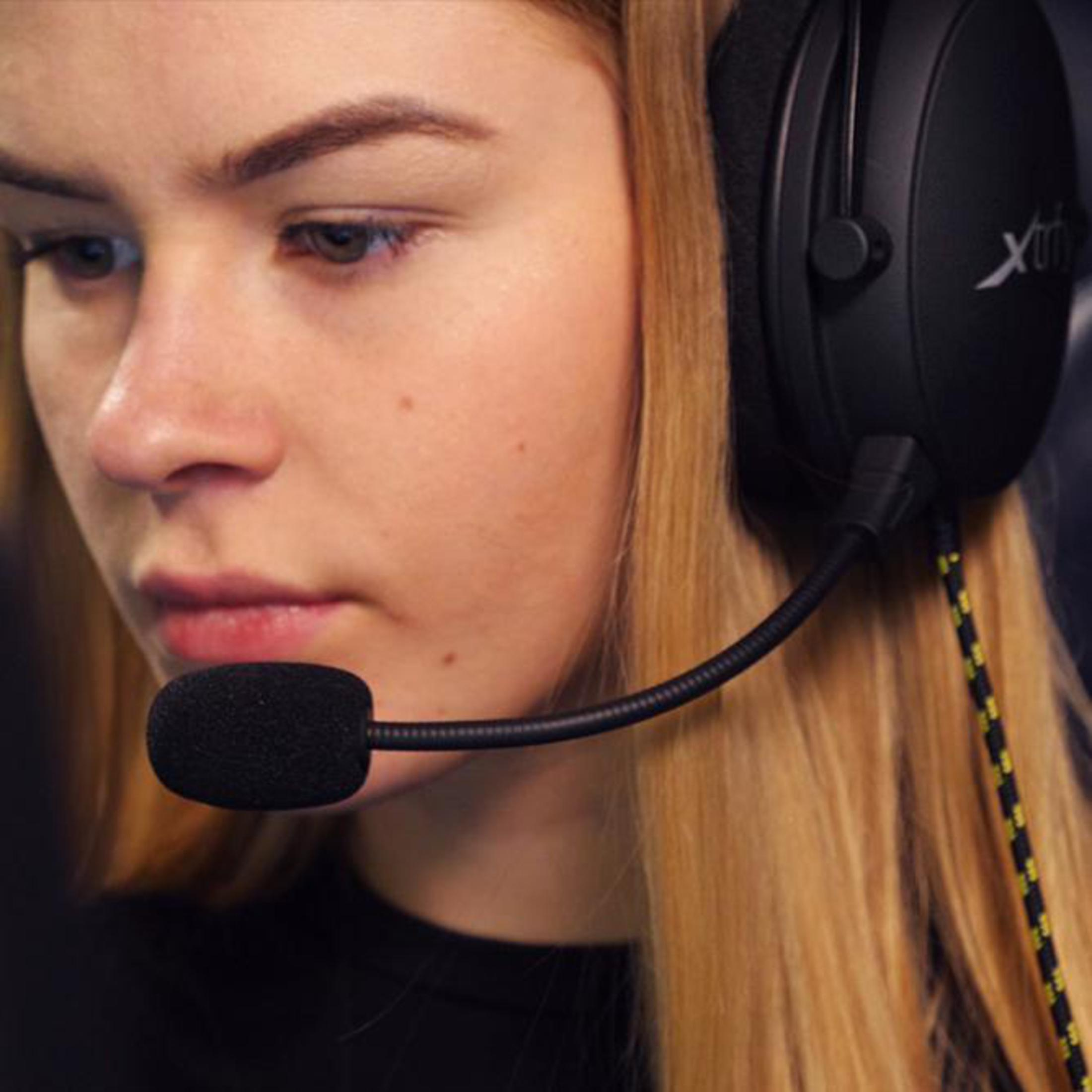 Eine junge Frau mit blonden Haaren trägt ein schwarzes Headset mit Mikrofon.