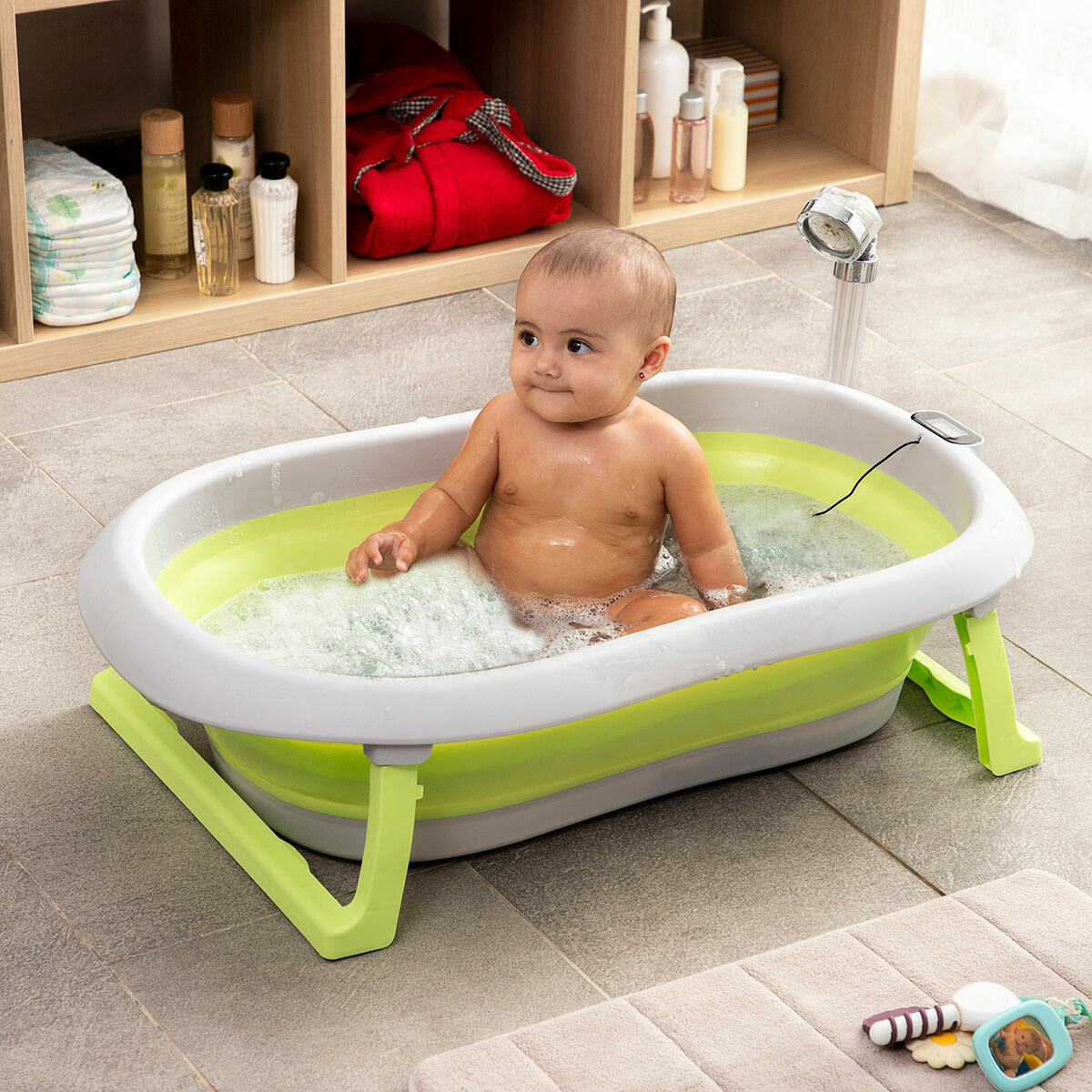 Ein Baby befindet sich in einer grün-grauen Wanne mit Blasen. Das Baby schaut zur Seite.