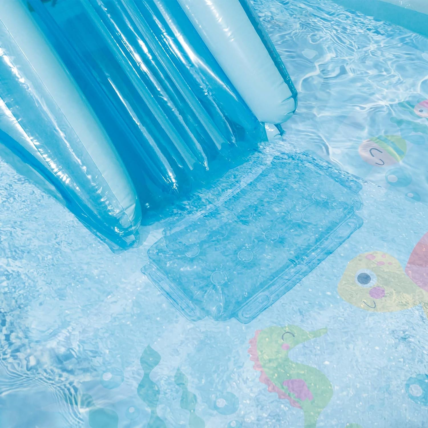 Ein blaues aufblasbares Becken mit Rutsche und Wasserdekorationen. Wasser ist sichtbar.