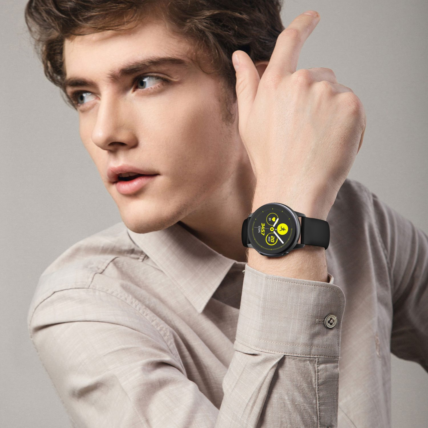 Ein Mann trägt eine schwarze Smartwatch am Handgelenk. Die Uhr zeigt die Zeit an.